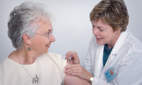 A doctor administering an intramuscular immunization to a middle&ndash;aged woman. Original image sourced from US Government department: Public Health Image Library, Centers for Disease Control and Prevention. Under US law this image is copyright free, please credit the government department whenever you can&rdquo;.