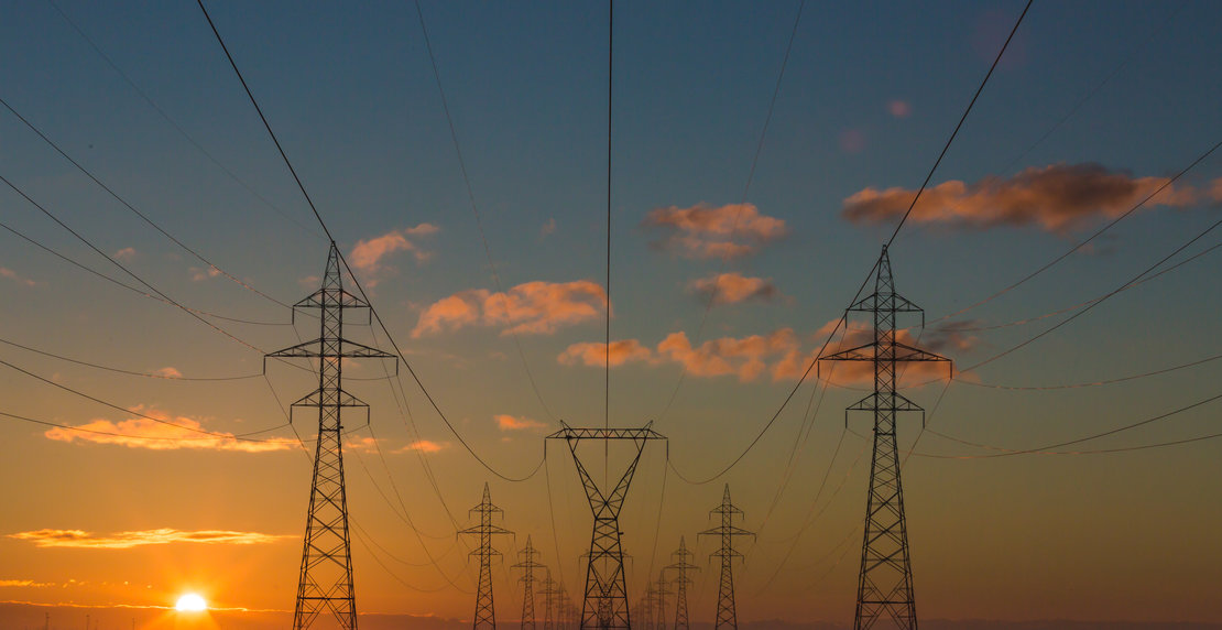 Electricity pylons at sunrise OR sunset, unidentified location. Original public domain image from Wikimedia Commons